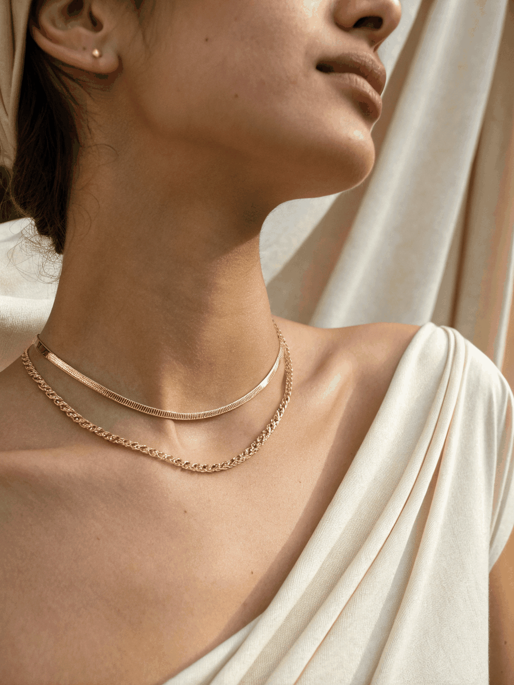 Gold pendant sitting against collarbone